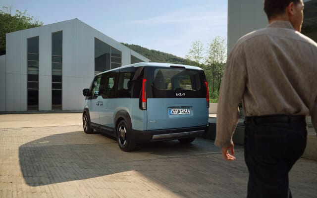 Seitenansicht eines PV5 Passenger, geparkt neben einer Heimladestation